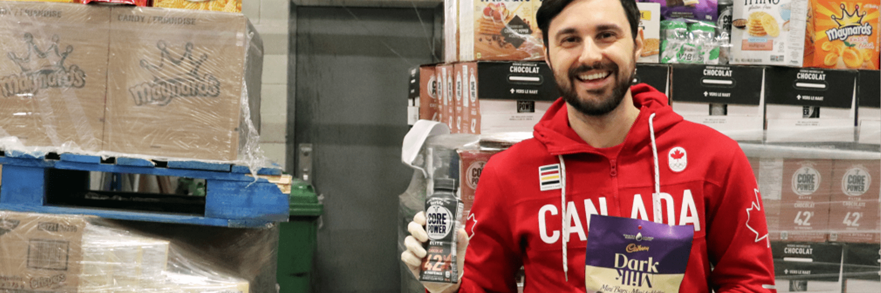 Une personne du Comité olympique canadien devant des dons d'aliments et de boissons