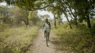 Femme en Afrique faisant du vélo dans une forêt